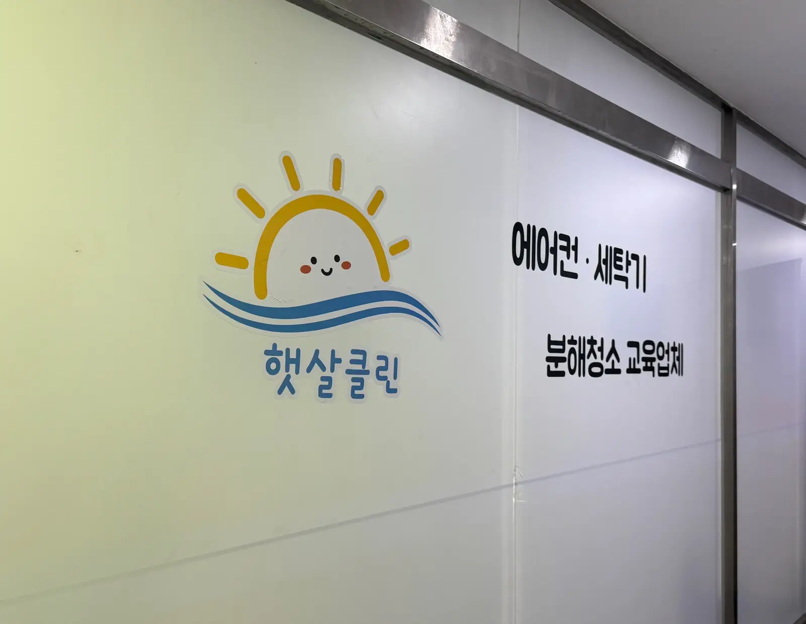 교육장 벽의 햇살클린 로고와 에어컨 · 세탁기 분해청소 교육업체 문구